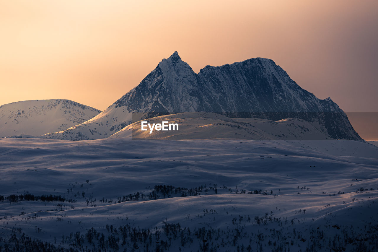 Scenic view of snowcapped mountains against sky during sunset