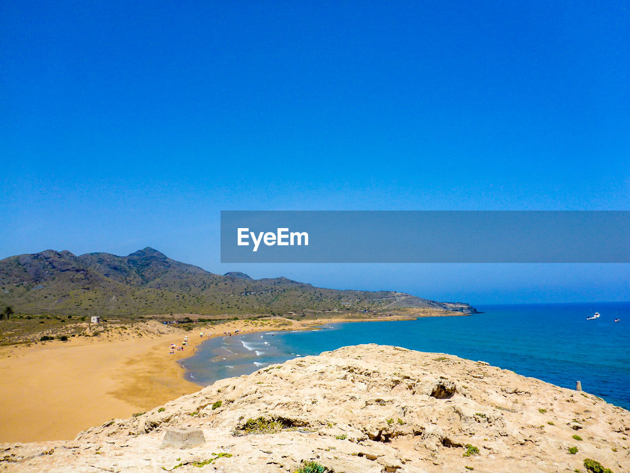 SCENIC VIEW OF BEACH AND MOUNTAINS AGAINST CLEAR BLUE SKY