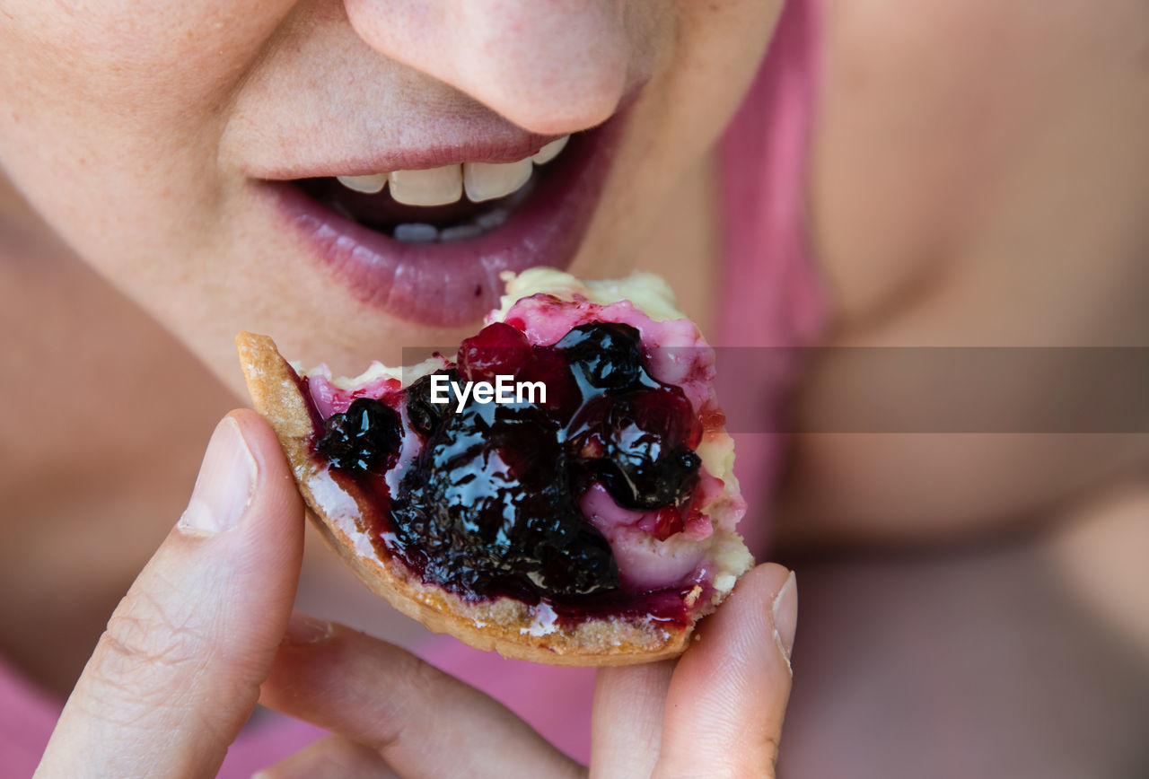 Close-up of woman eating tart