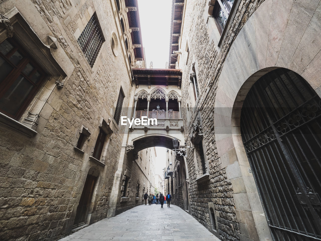 PEOPLE IN ALLEY AMIDST BUILDINGS