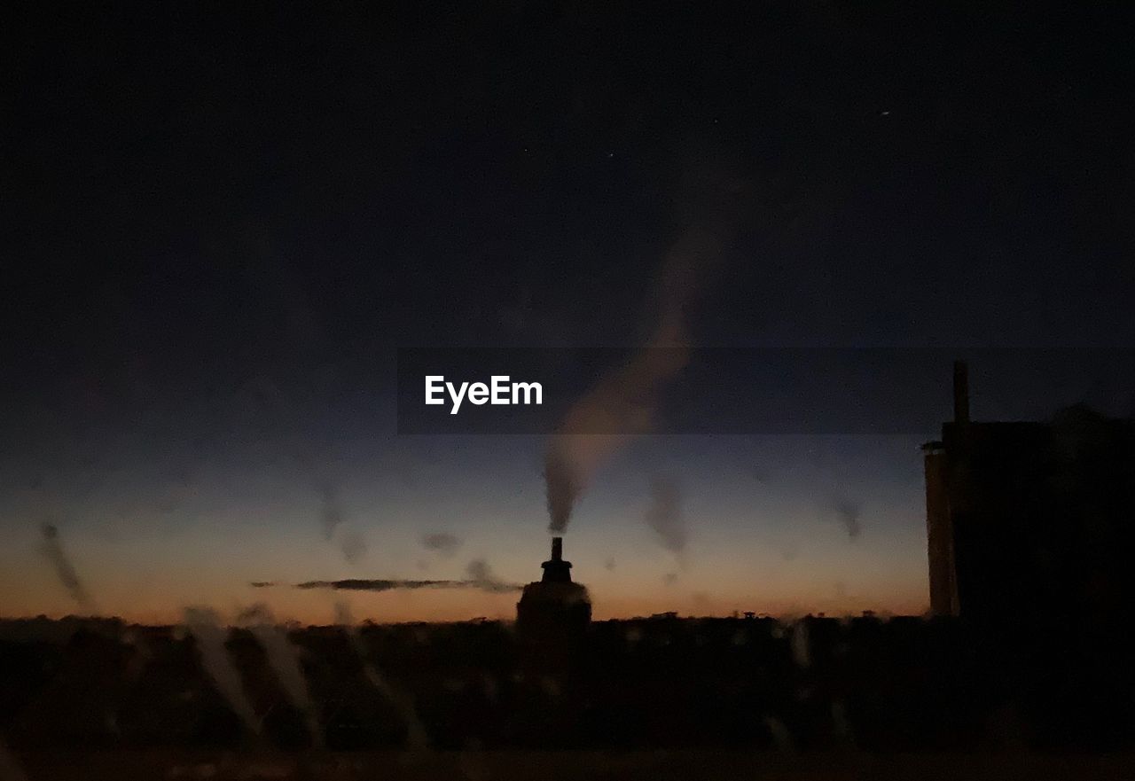 SILHOUETTE OF BUILDINGS AGAINST CLOUDY SKY