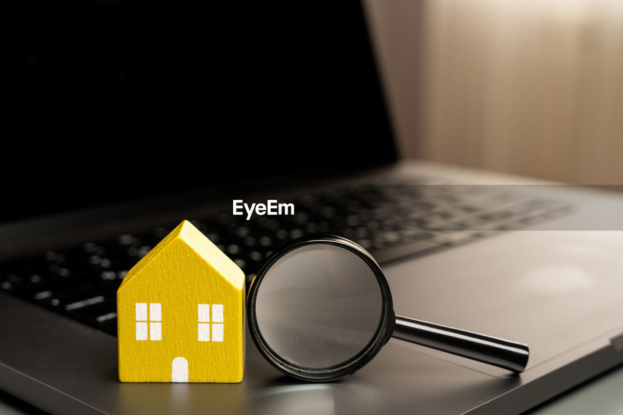 House and magnifying glass on laptop keyboard. the concept of searching for housing 