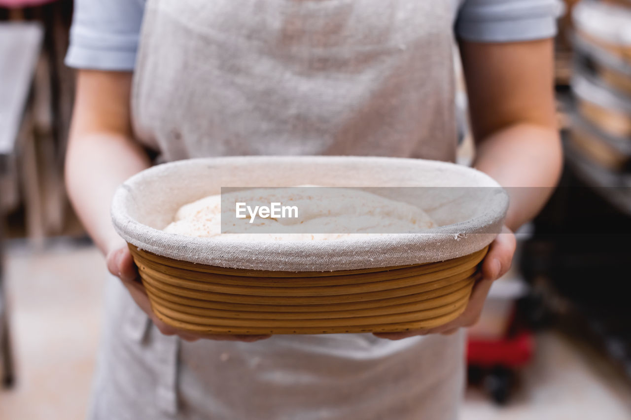 Women's hands hold the dough before putting it in the oven. close-up of baker's hands