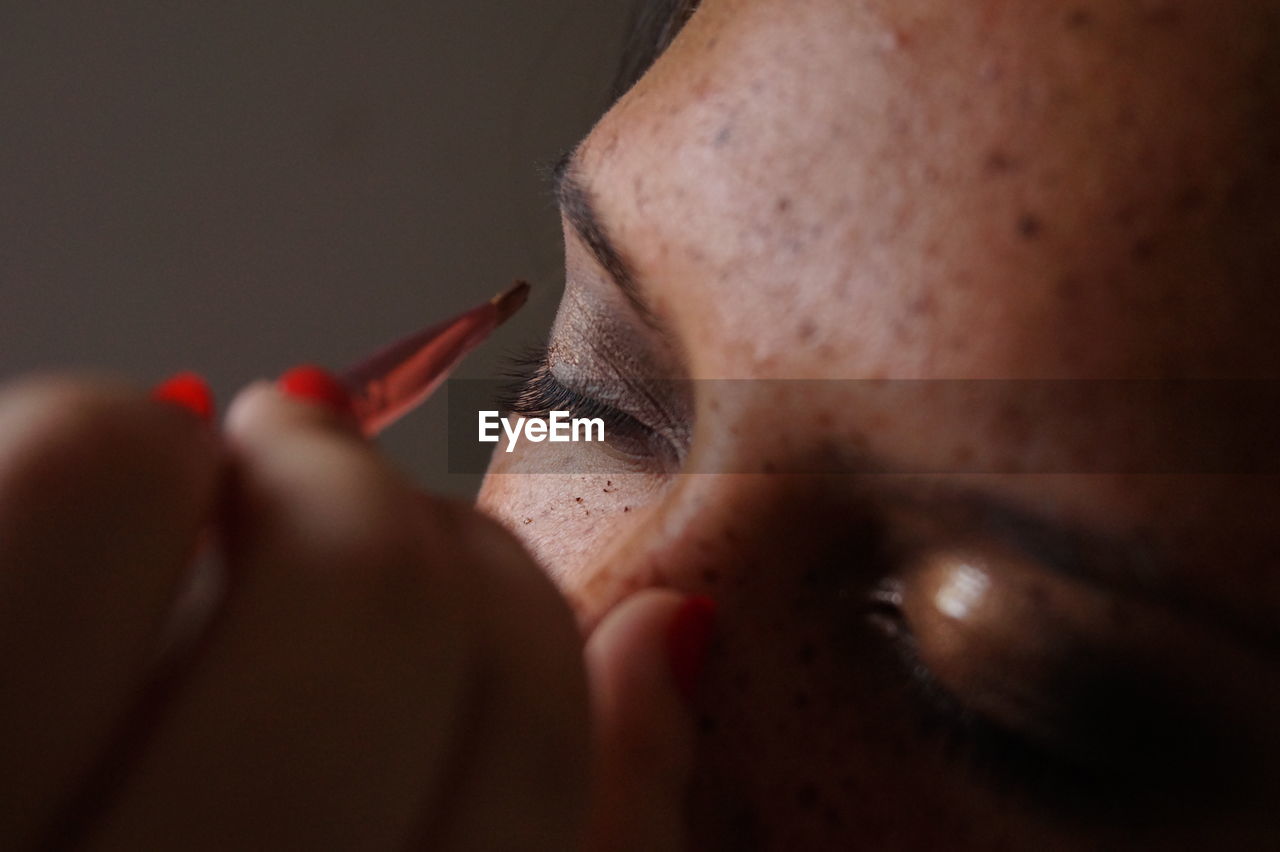 Close-up of young woman doing make-up