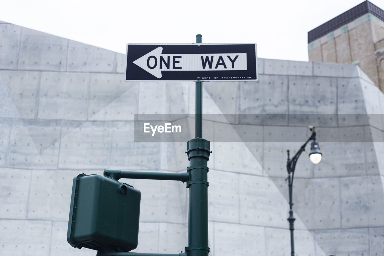 Low angle view of road sign against built structure