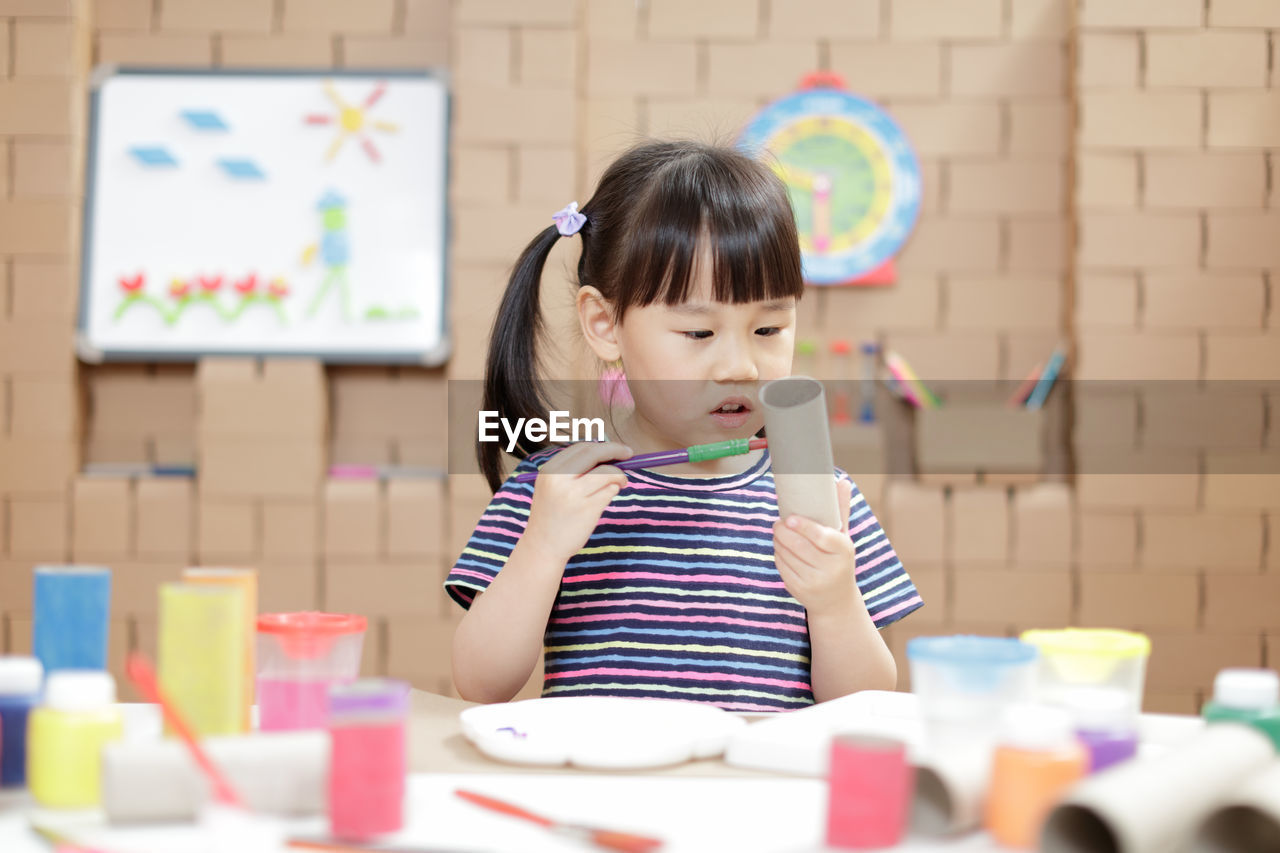 Portrait of young girl making craft for home schooling