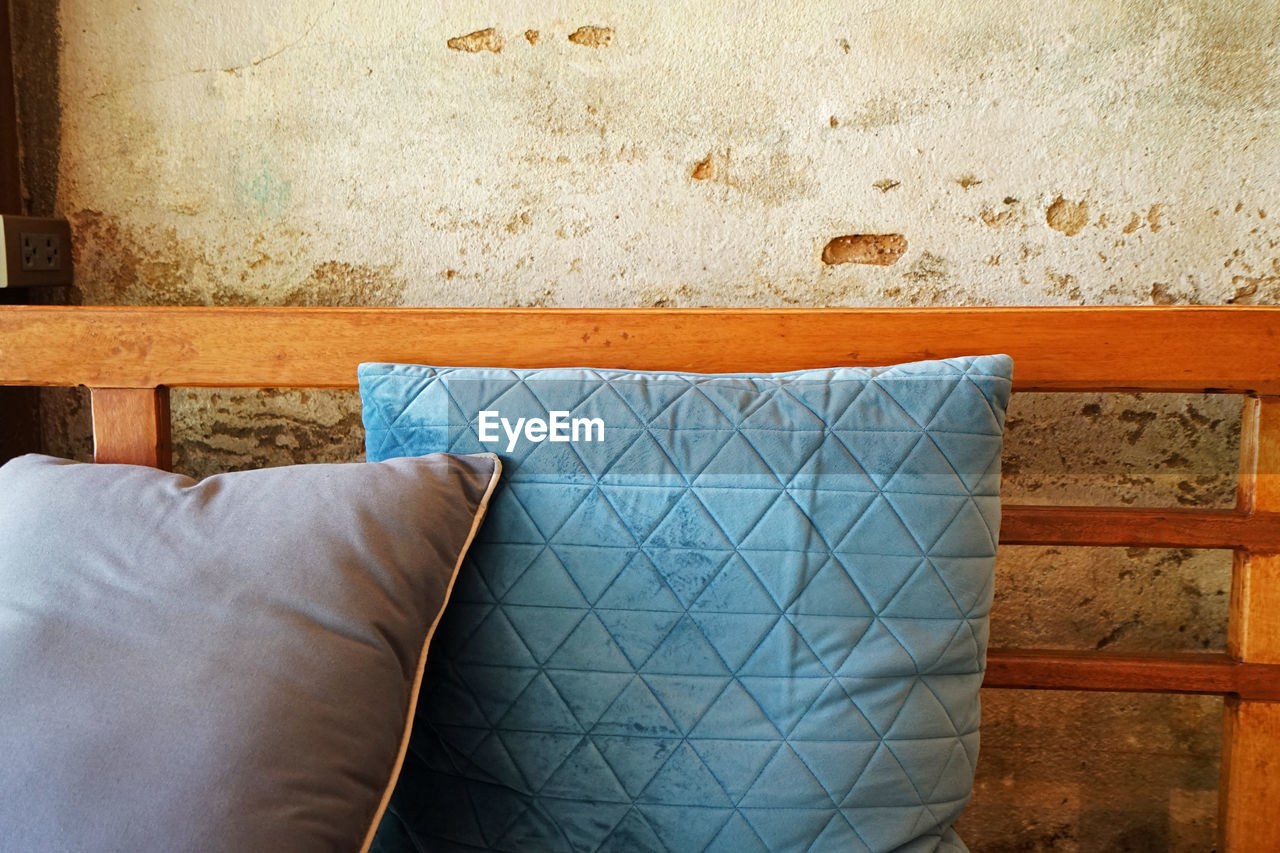 Close-up of cushion against wall at home