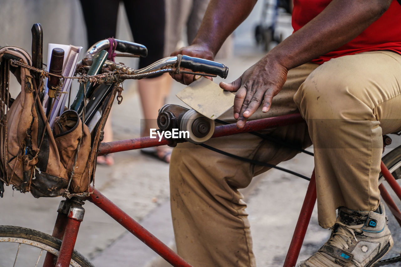 Midsection of knife sharpener sitting on bicycle