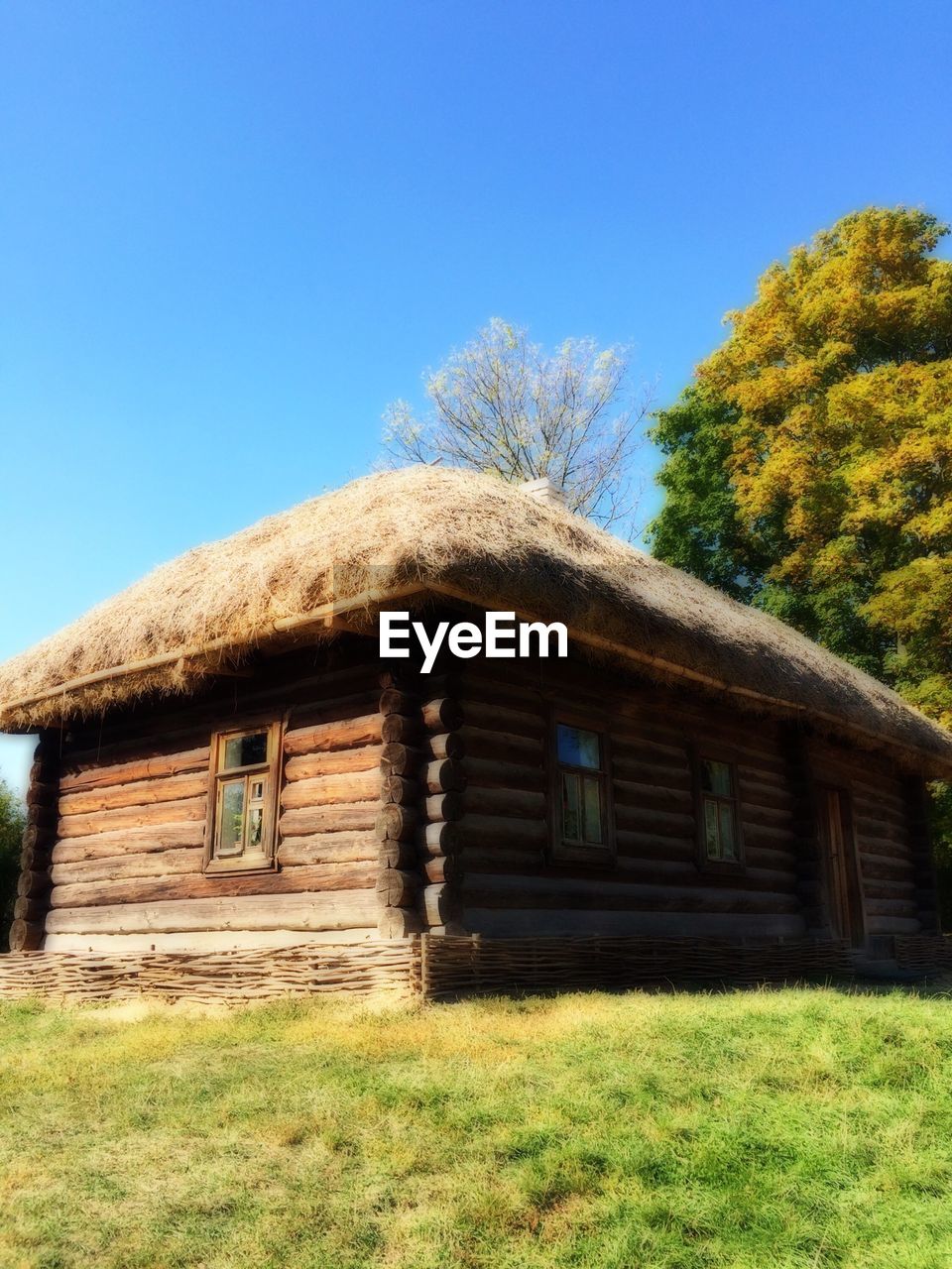 View of wooden cottage against blue sky