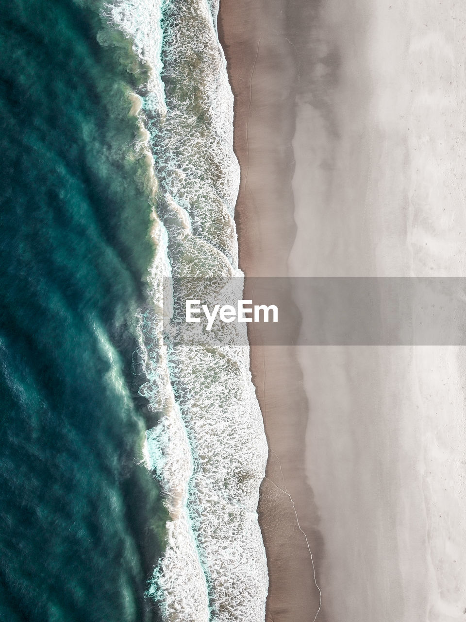 Aerial view of sea waves rushing at beach