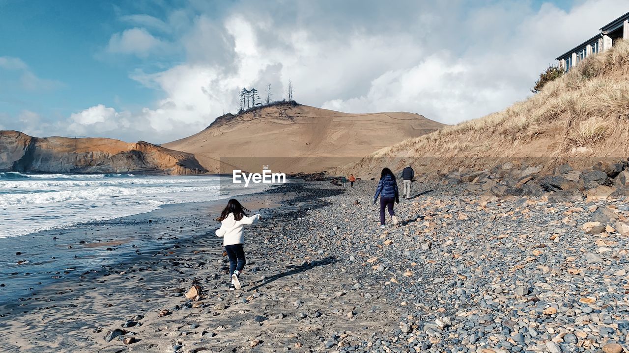 Rear view of people walking near dune