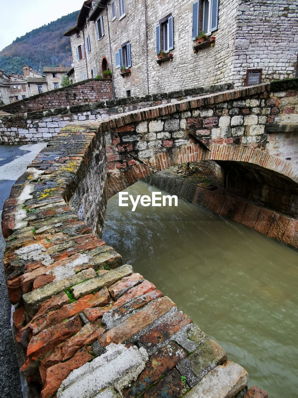 Bridge over river against buildings