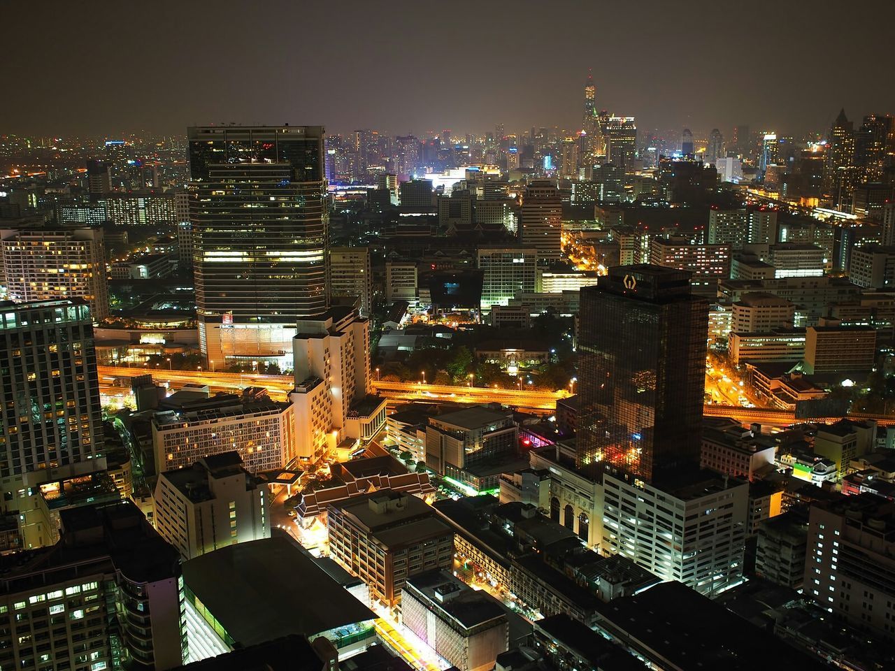 High angle view of illuminated cityscape against sky at night