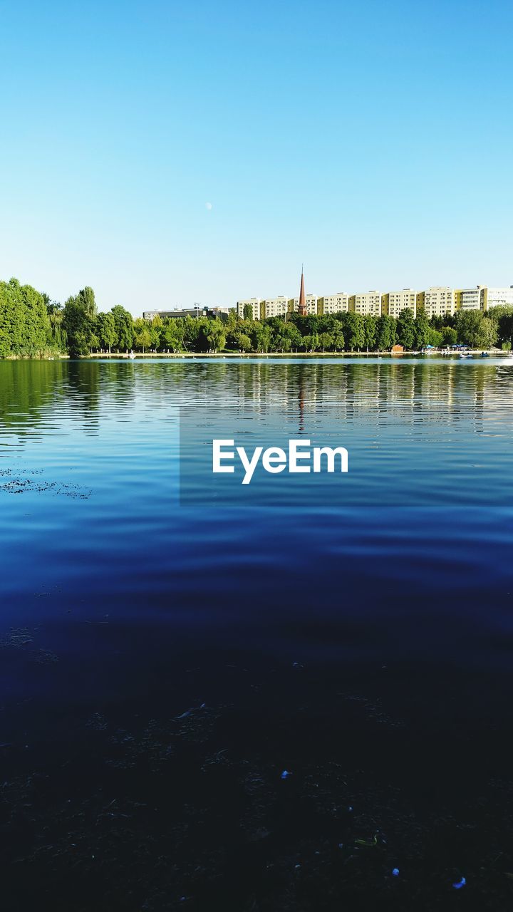 Scenic view of lake against clear blue sky