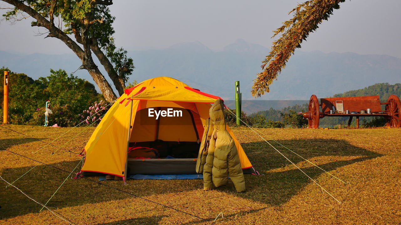 TENT ON FIELD AGAINST TREES