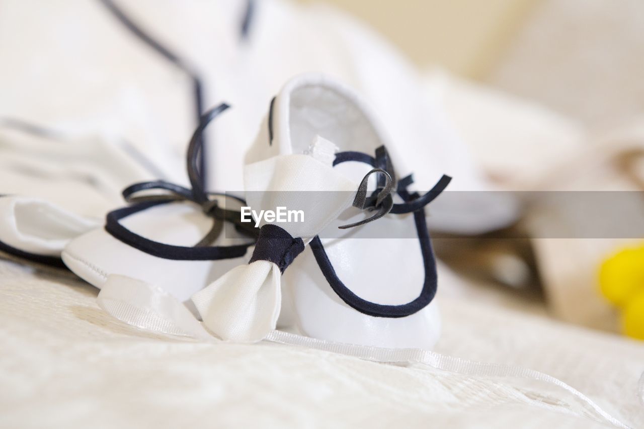 Close-up of white baby booties on table