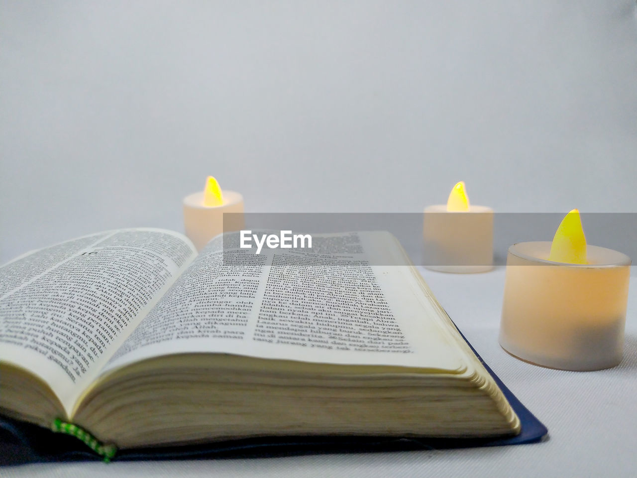 CLOSE-UP OF CANDLES ON BOOK