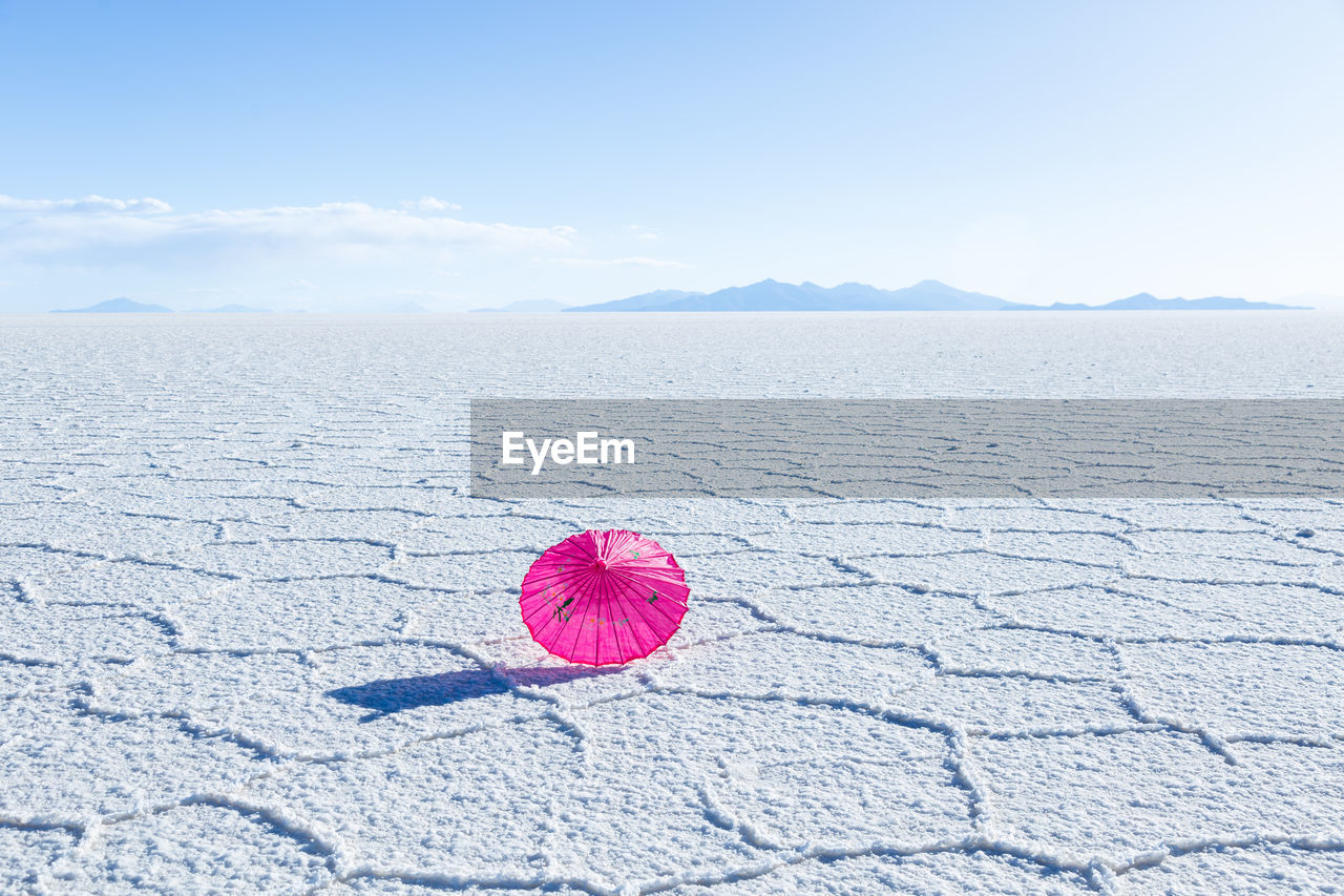 Pretty pink parasol set on the uyuni salt flat during a sunny day, bolivia