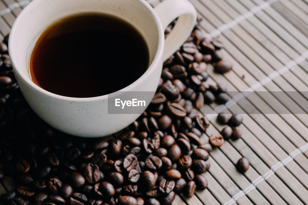 HIGH ANGLE VIEW OF COFFEE CUP ON TABLE WITH BLACK BACKGROUND