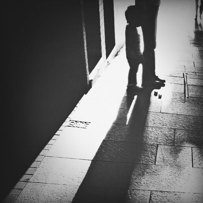 LOW SECTION OF WOMAN STANDING ON TILED FLOOR