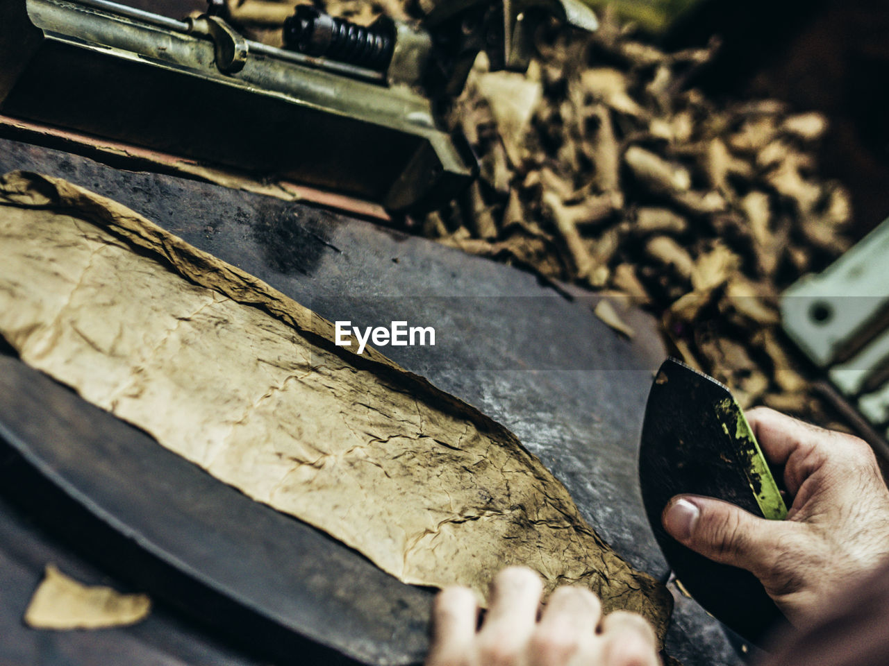 Close-up of manual worker making cigar in factory