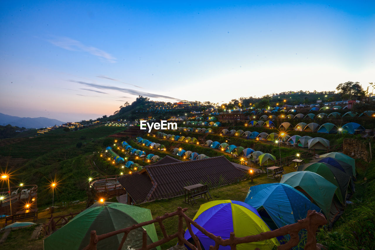 HIGH ANGLE VIEW OF TENTS ON FIELD AGAINST SKY