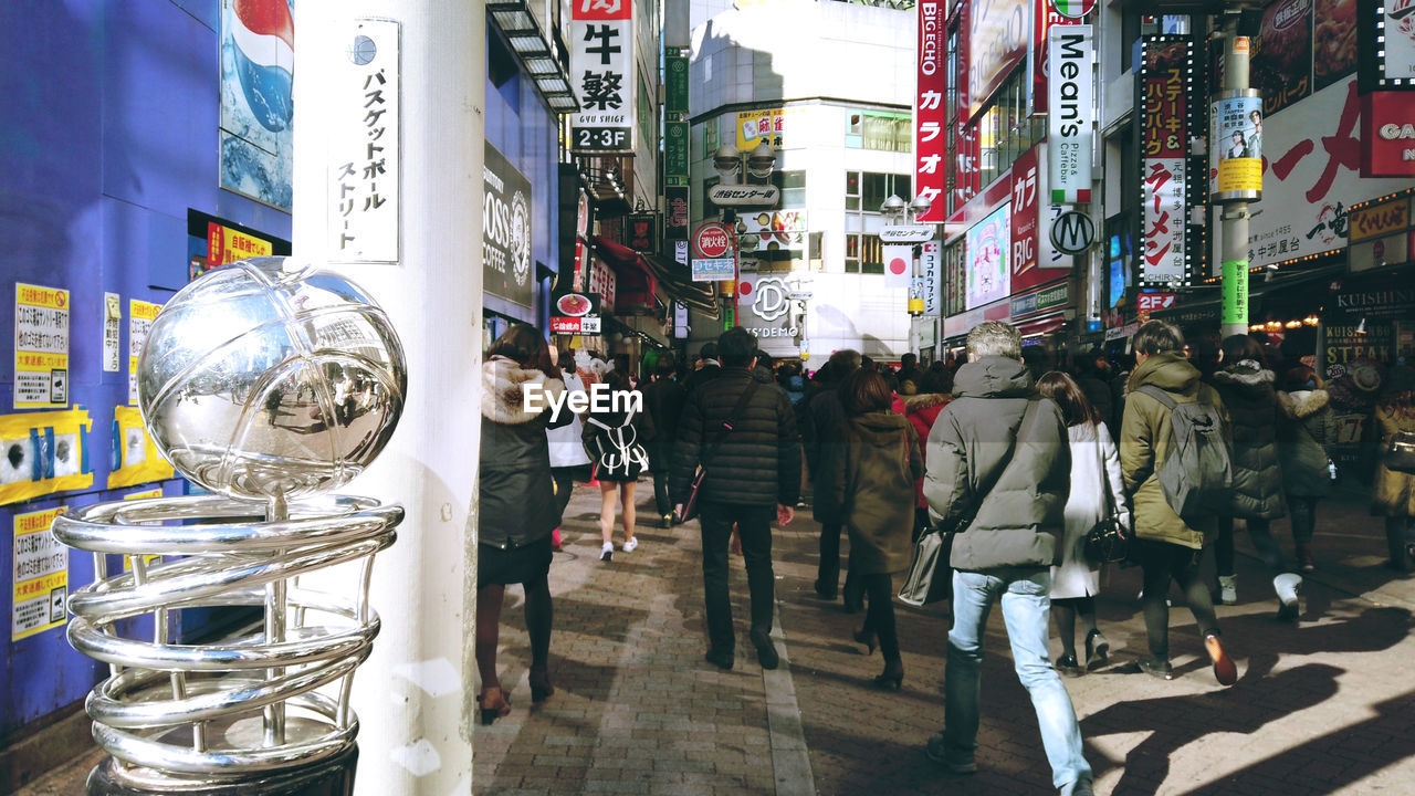 GROUP OF PEOPLE WALKING ON STREET