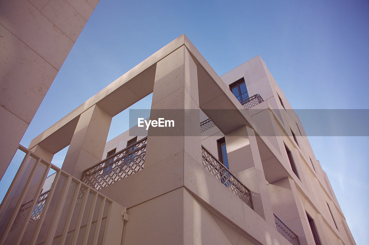 Low angle view of modern building against clear blue sky