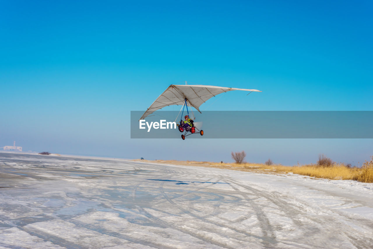 White sport hang glider on an ice field