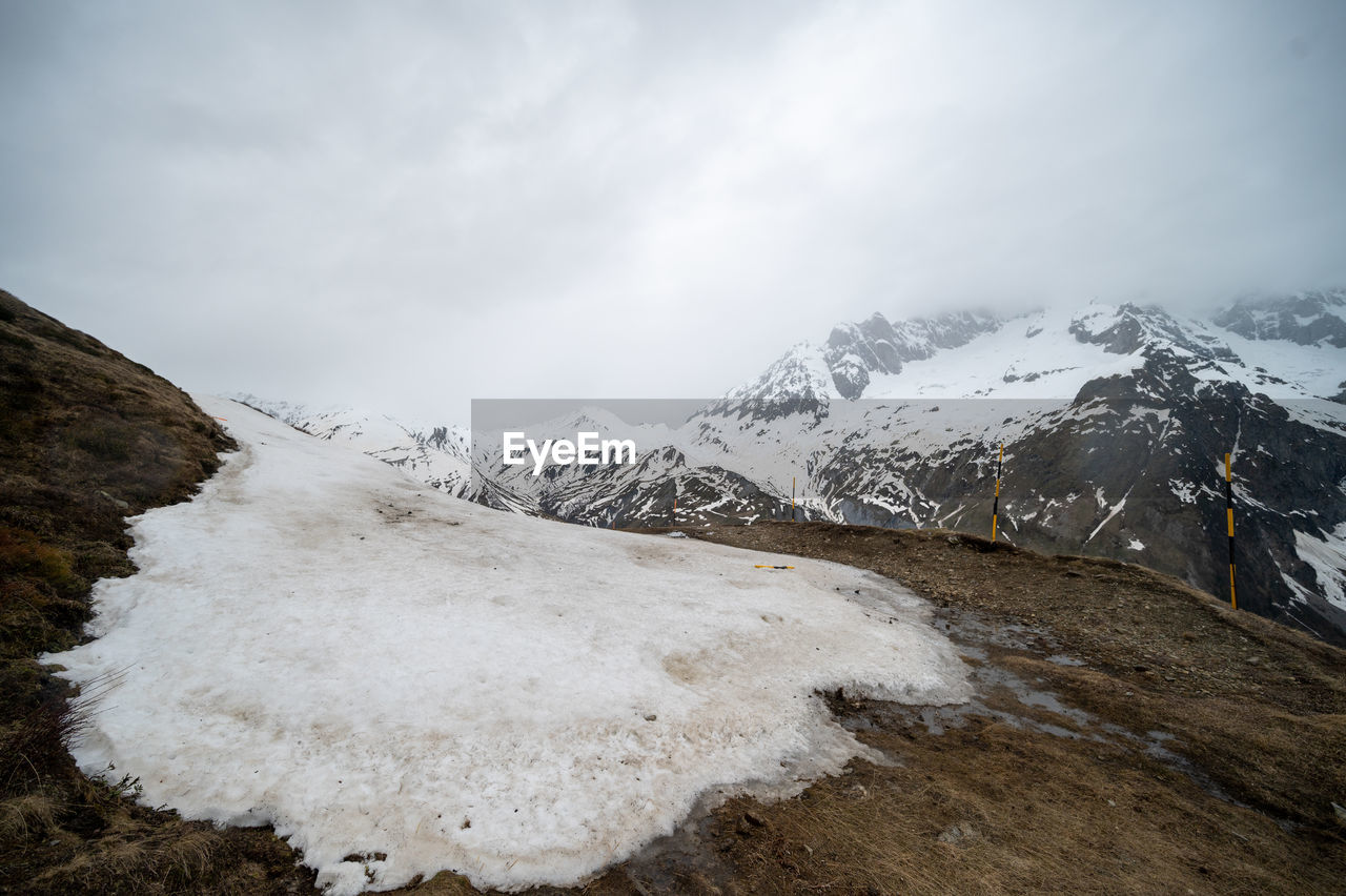 snow, mountain, cold temperature, winter, environment, landscape, scenics - nature, sky, nature, beauty in nature, cloud, snowcapped mountain, mountain range, travel destinations, travel, ice, ridge, no people, land, tourism, wilderness, non-urban scene, tranquility, frozen, outdoors, mountain peak, summit, fog, tranquil scene, overcast, glacier, adventure, day, extreme terrain, polar climate, glacial landform, activity, plateau, water, mountain pass, rock, outdoor pursuit, white