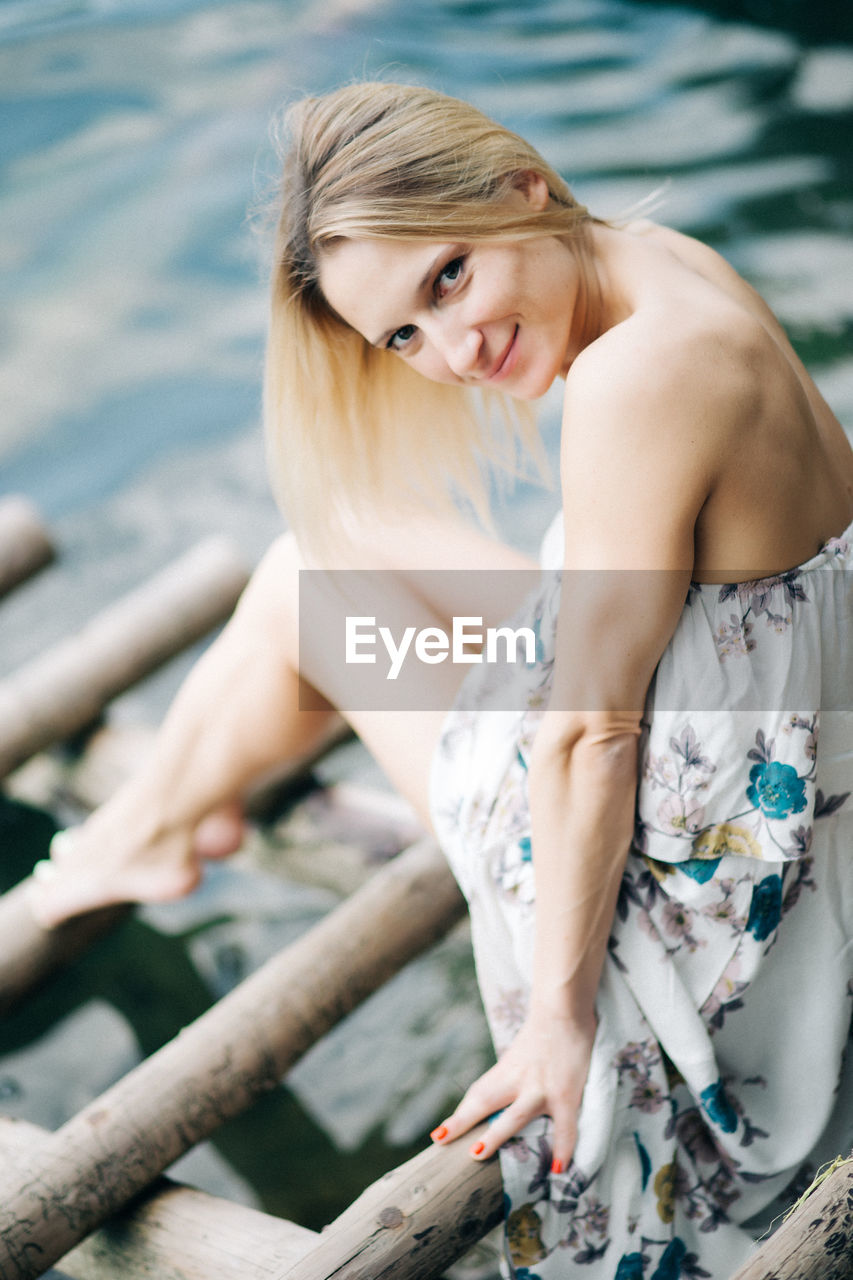 MIDSECTION OF WOMAN SITTING IN SEA