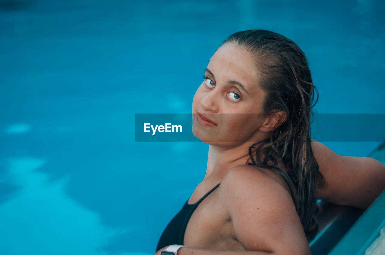 Portrait of smiling young woman in swimming in pool