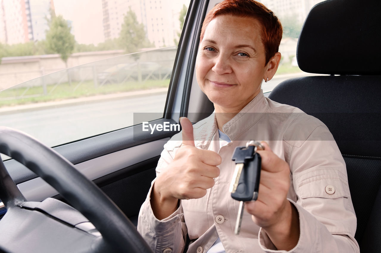 portrait of woman using mobile phone while sitting in car
