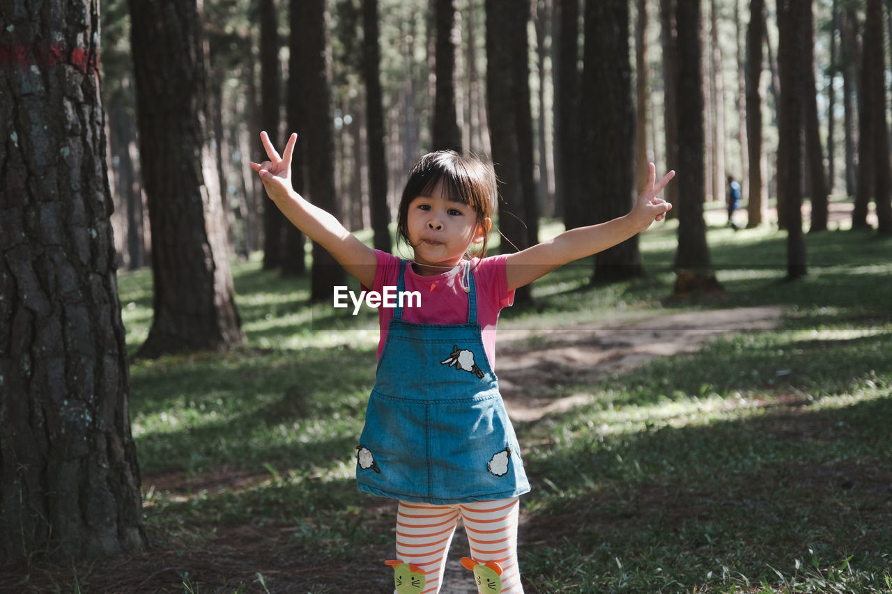 Portrait of cute girl standing in forest