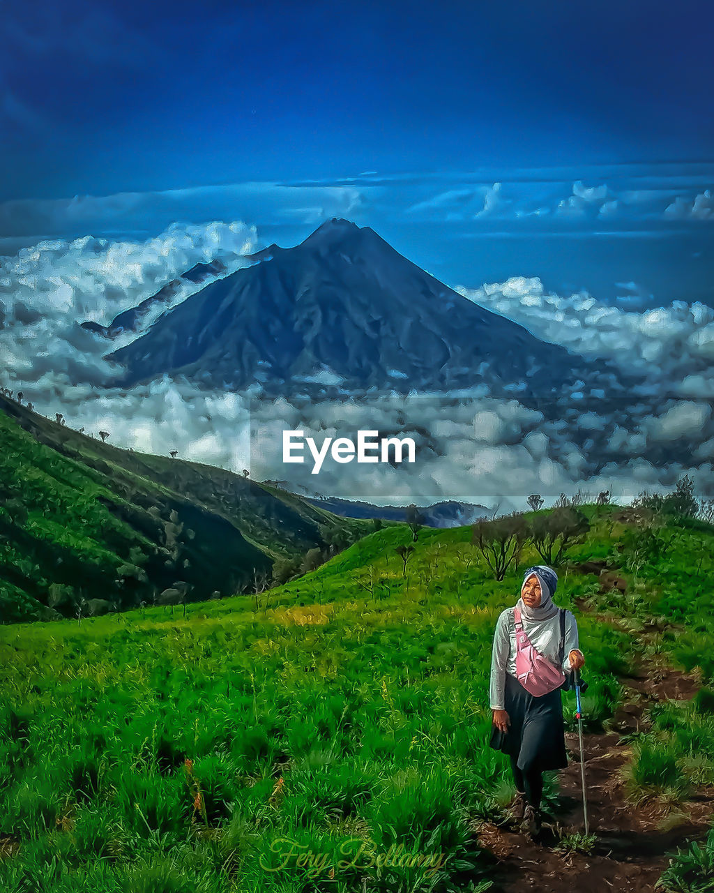 Woman standing on field against mountain range