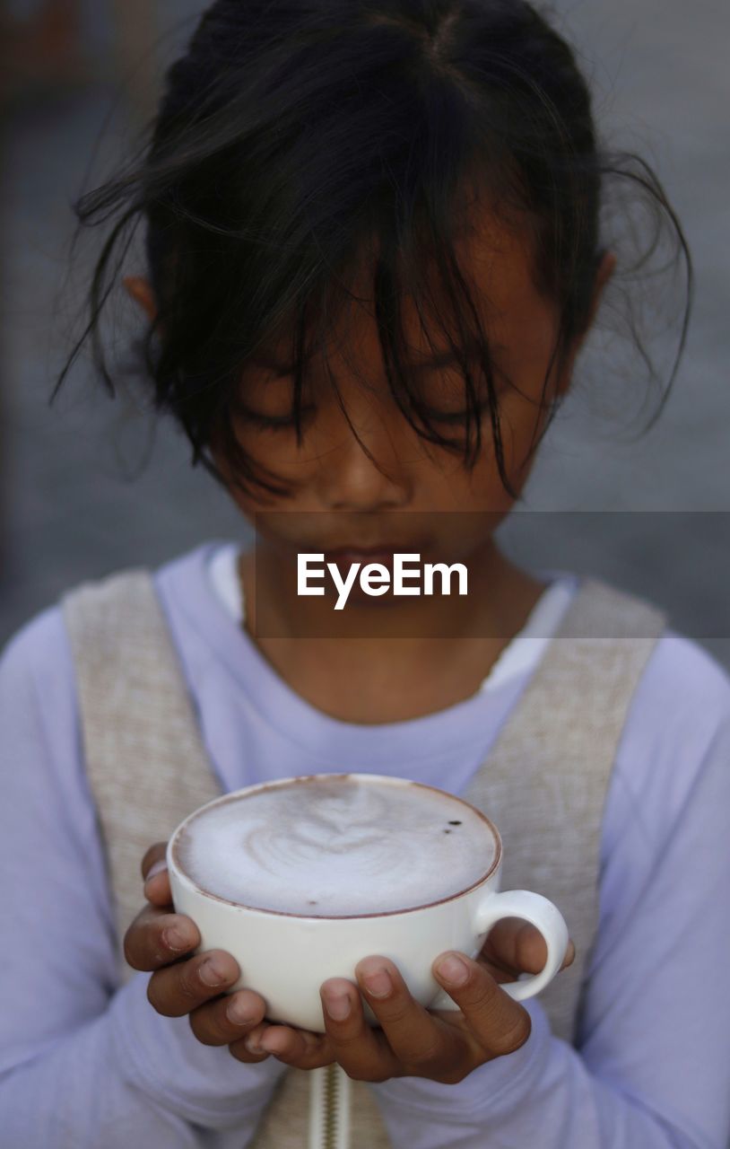 Close-up of girl holding coffee cup