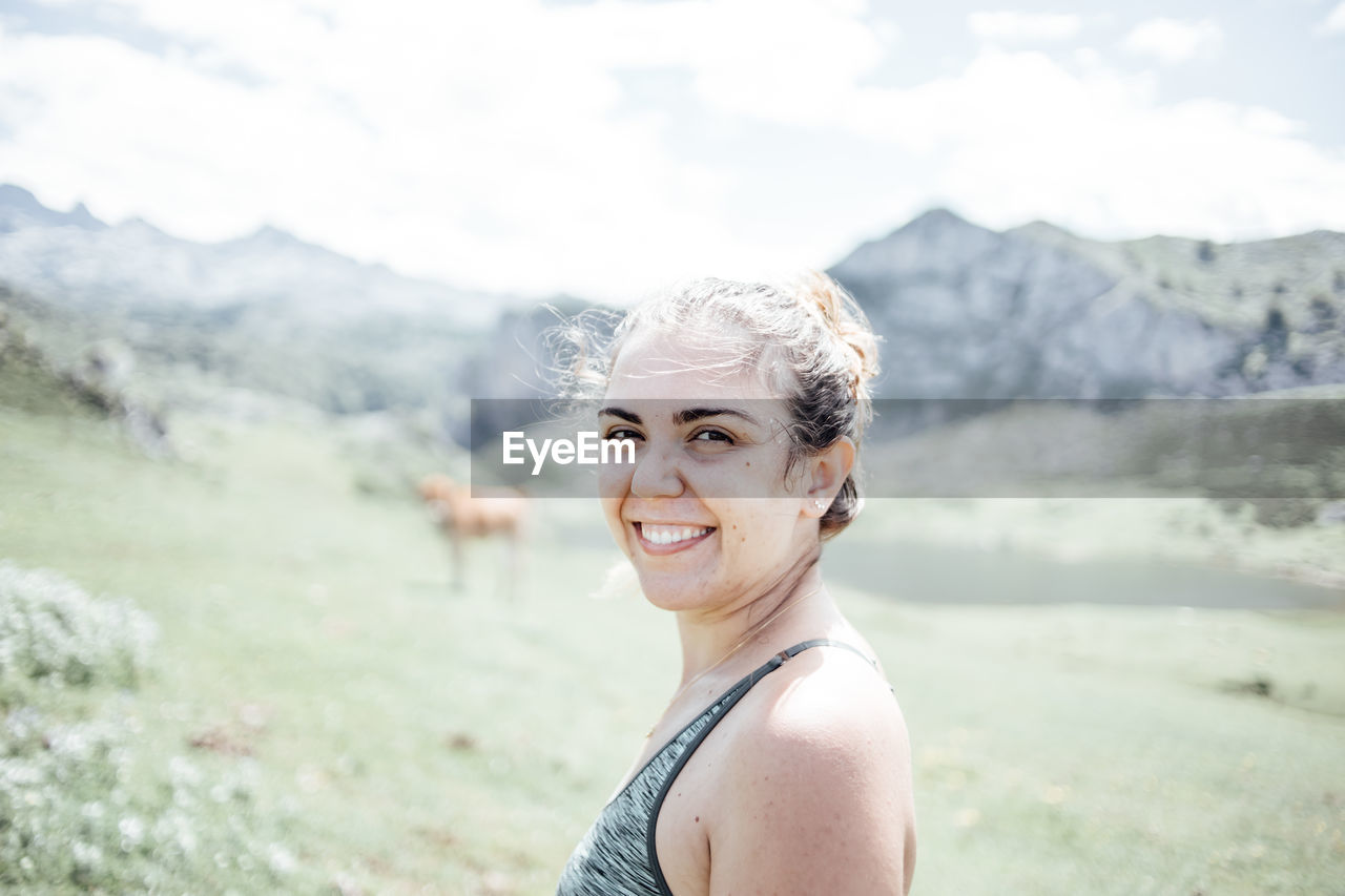 portrait of young woman standing on field