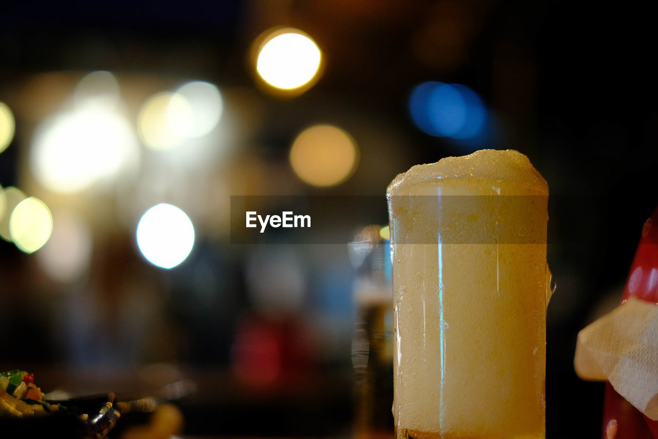 CLOSE-UP OF BEER GLASS ON TABLE