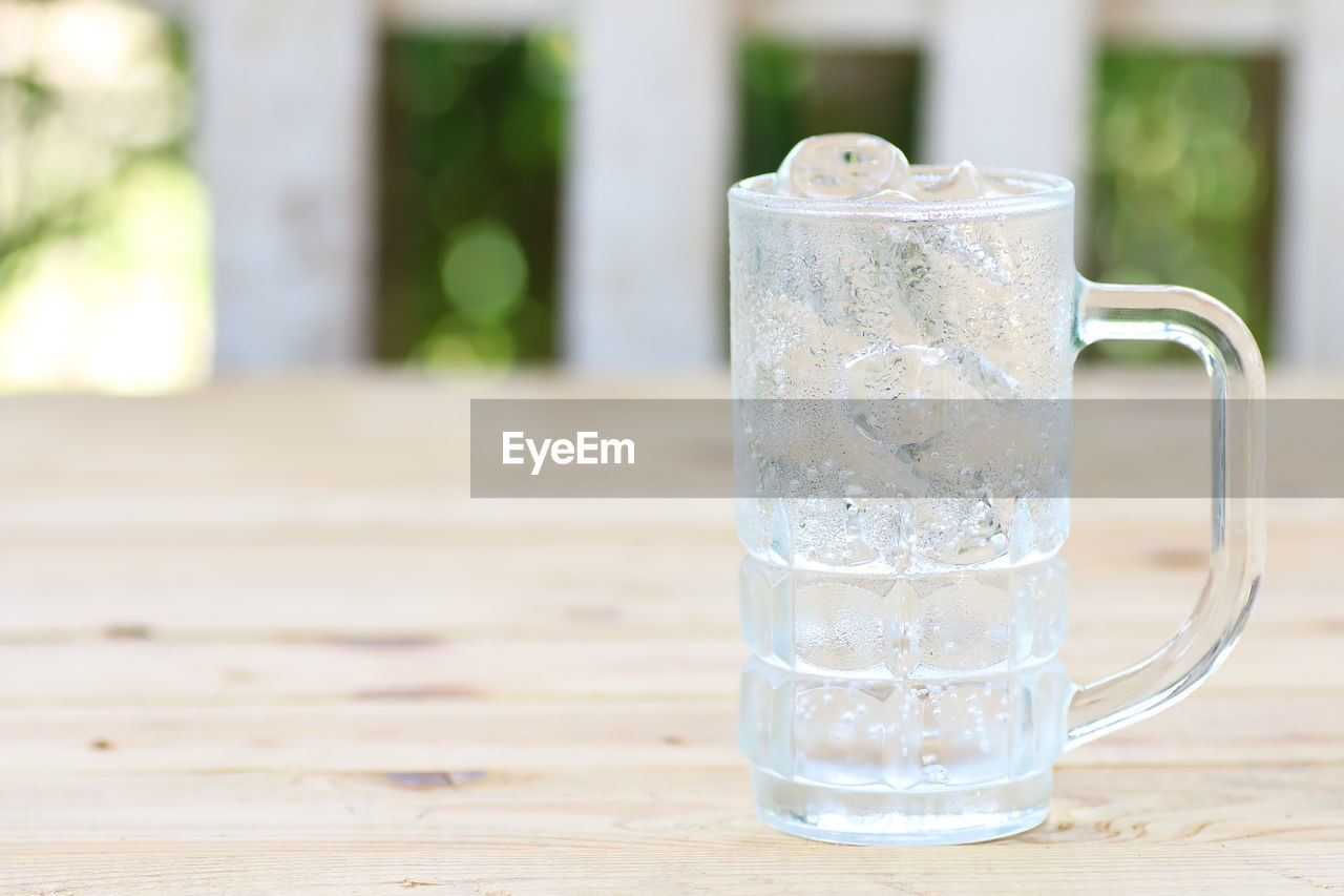 CLOSE-UP OF GLASS OF WATER ON TABLE