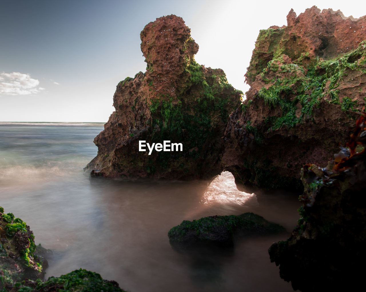 Rock formations by sea against sky