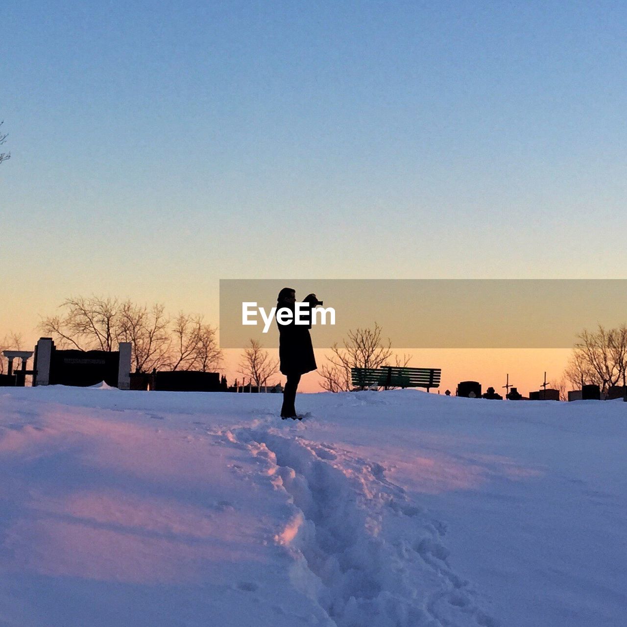 SILHOUETTE OF PERSON STANDING ON SNOW