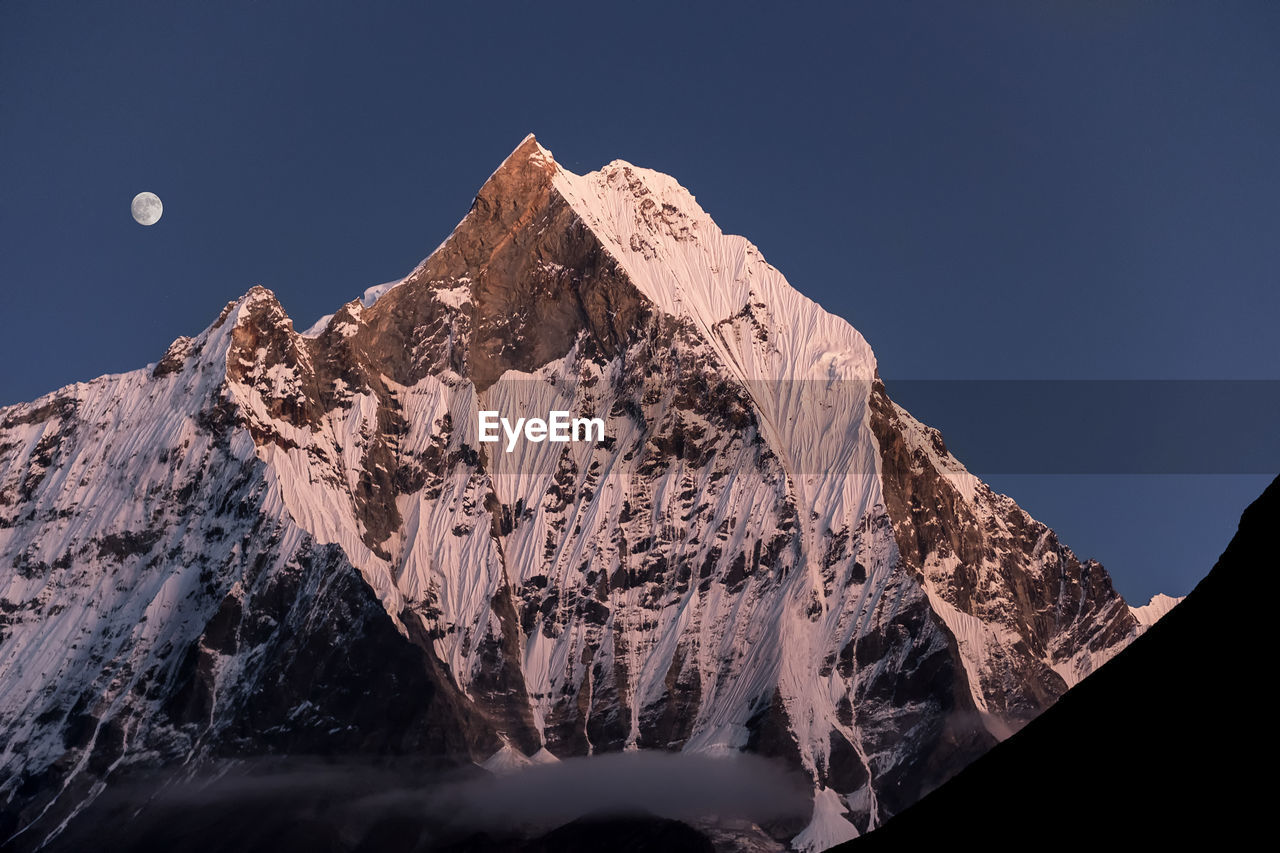 Panoramic view of snowcapped mountains against clear sky