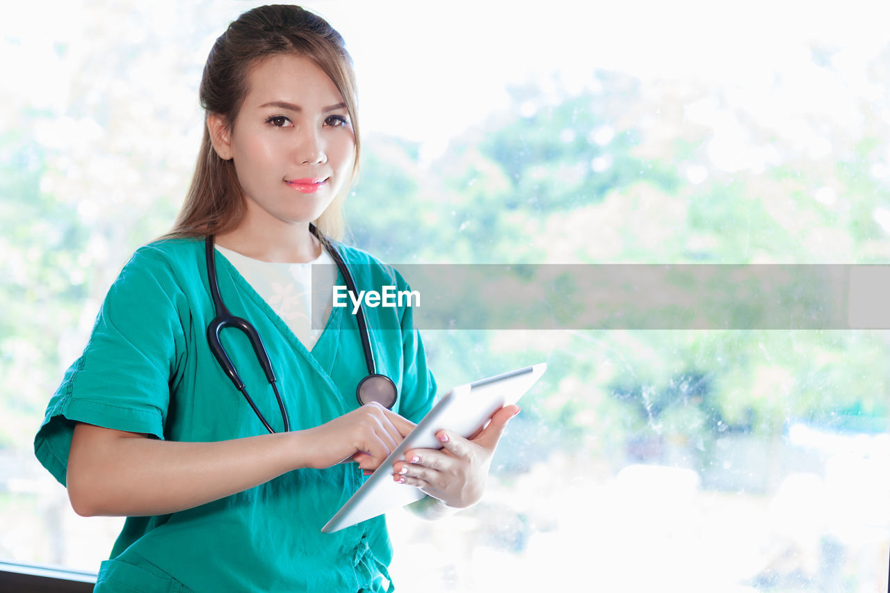 Portrait of young female doctor using digital tablet