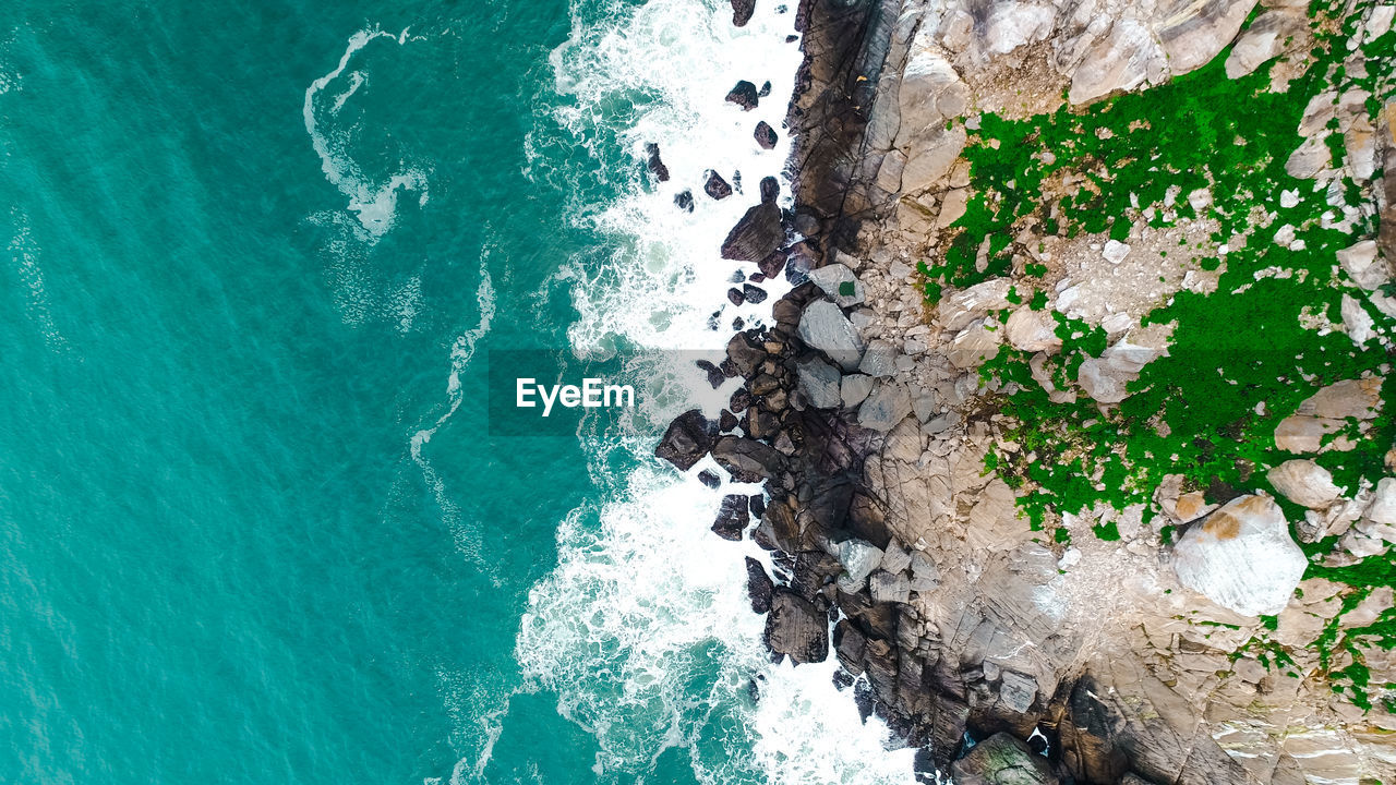 HIGH ANGLE VIEW OF ROCK FORMATIONS AT SEA