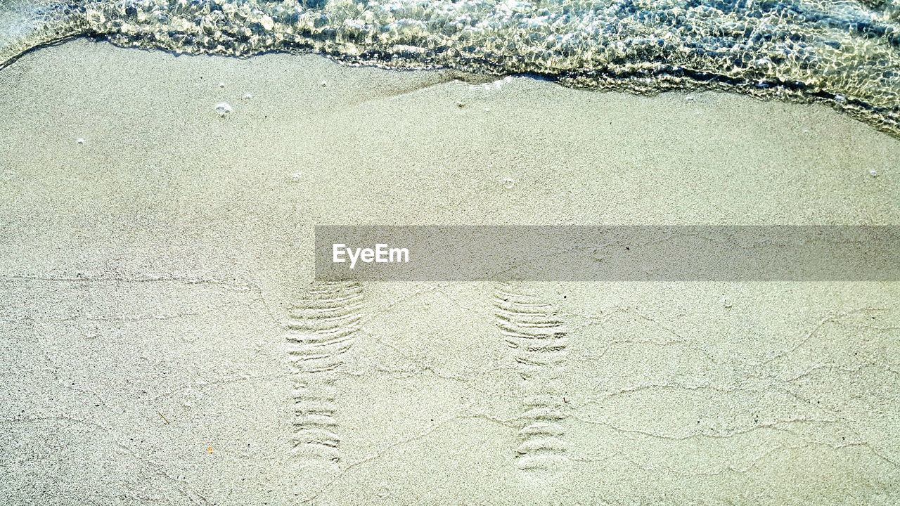 Footprint at beach on sunny day