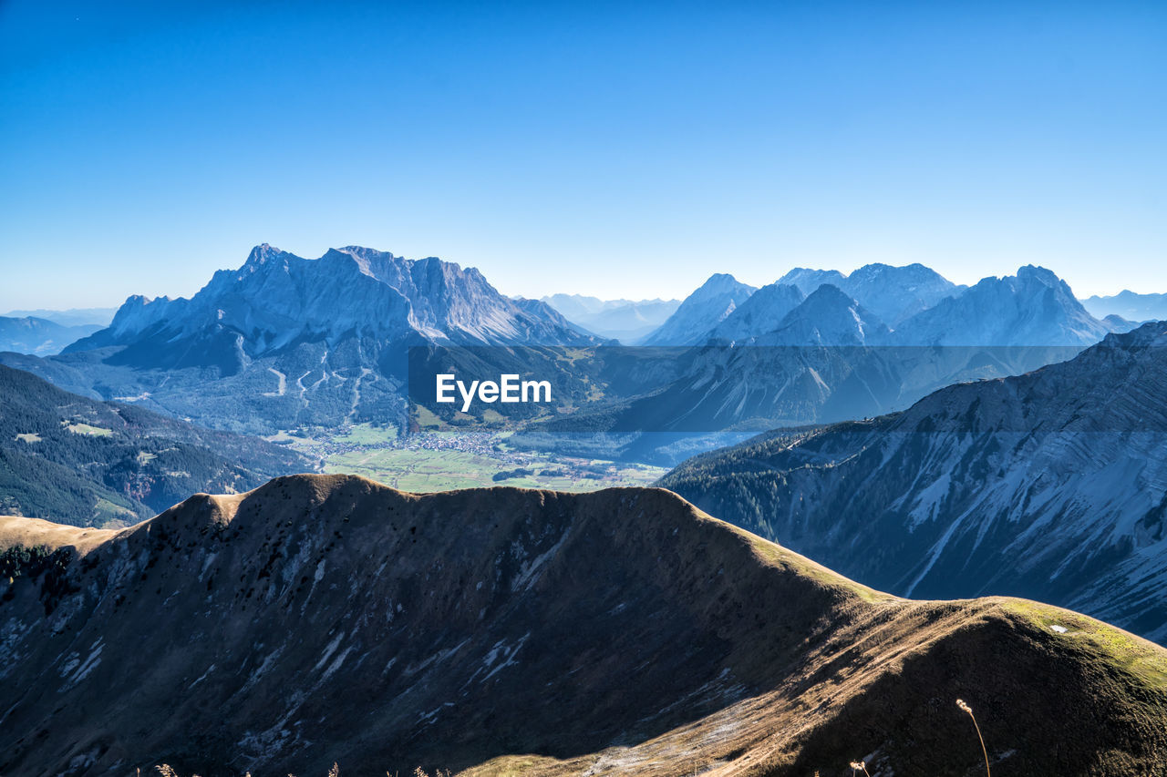 Scenic view of snowcapped mountains against clear blue sky