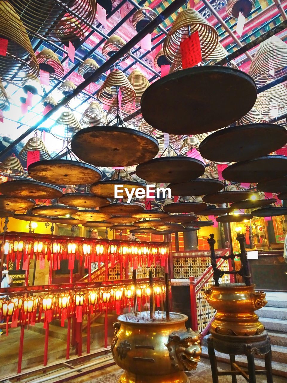 LOW ANGLE VIEW OF ILLUMINATED LIT CANDLES IN TEMPLE