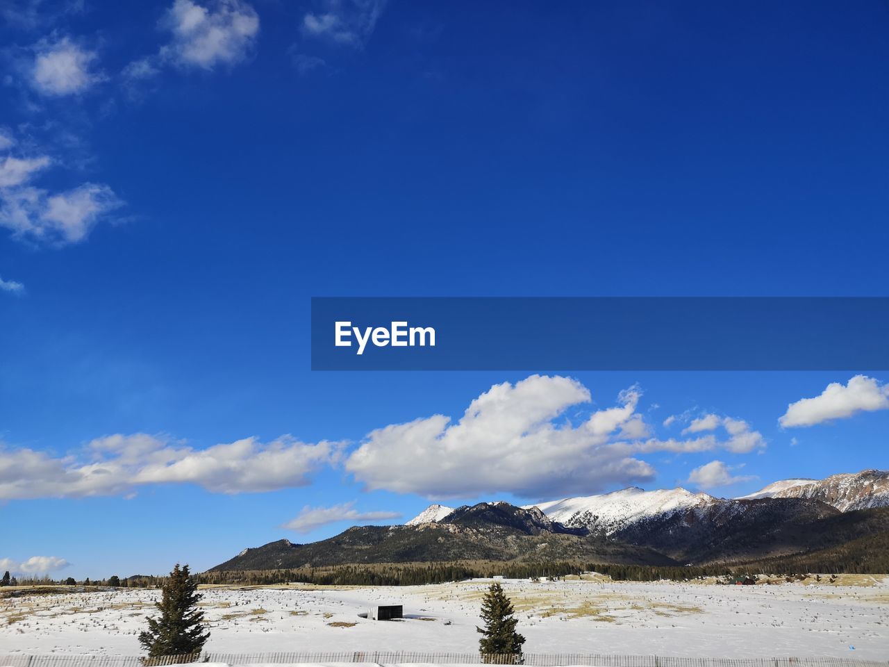 Scenic view of snowcapped mountains against blue sky