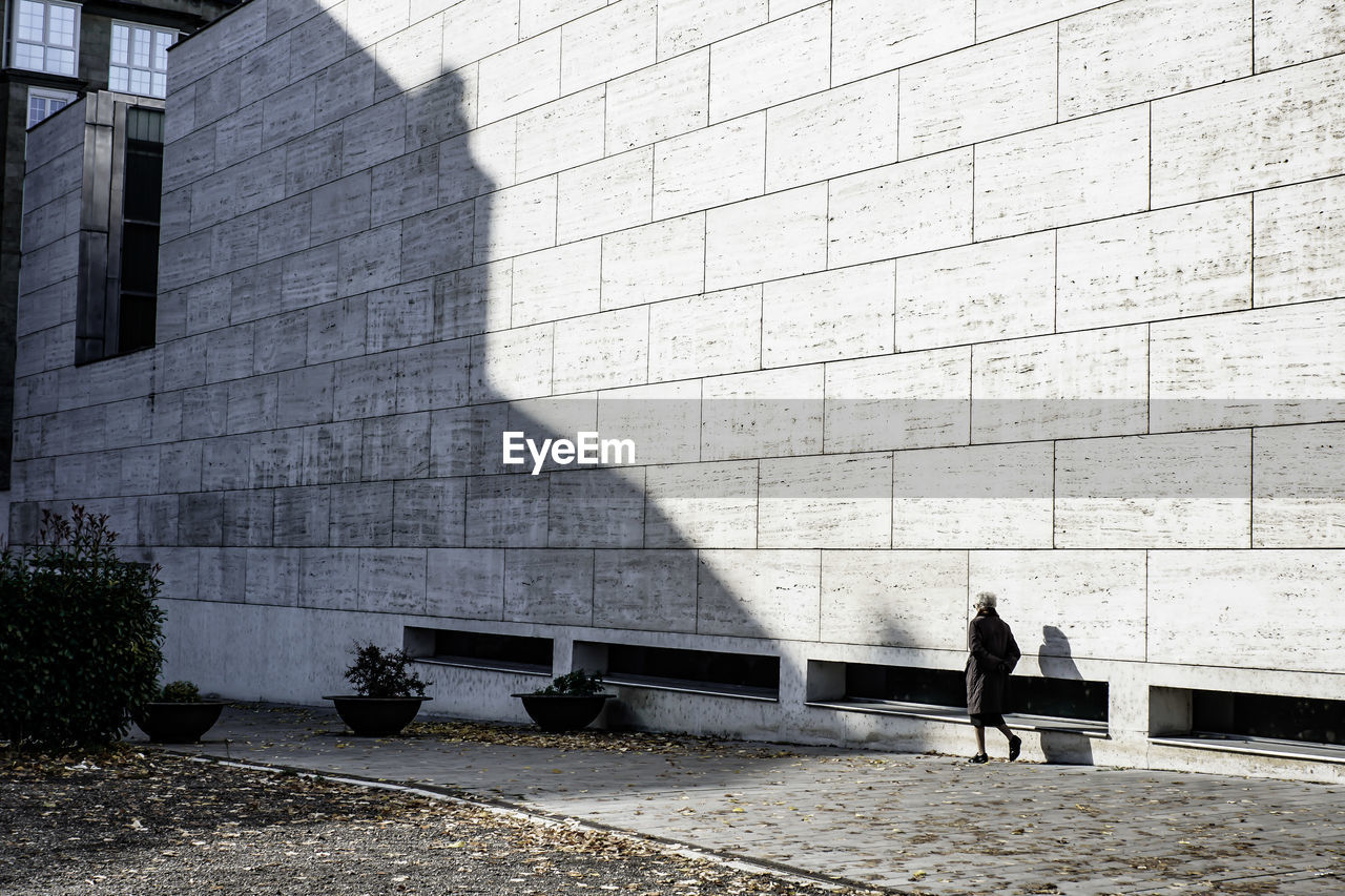 People walking on wall against building