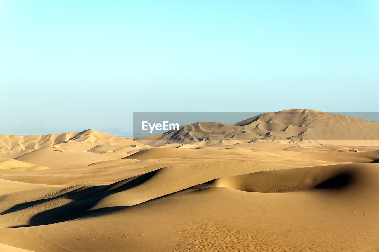 Scenic view of desert landscape against clear sky at huacachina